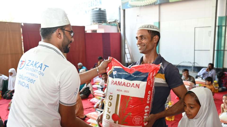 A father in India is all smiles with Ramadan food for his family /  أب من الهند يبتسم أثناء حصوله توزيعات رمضان 2023