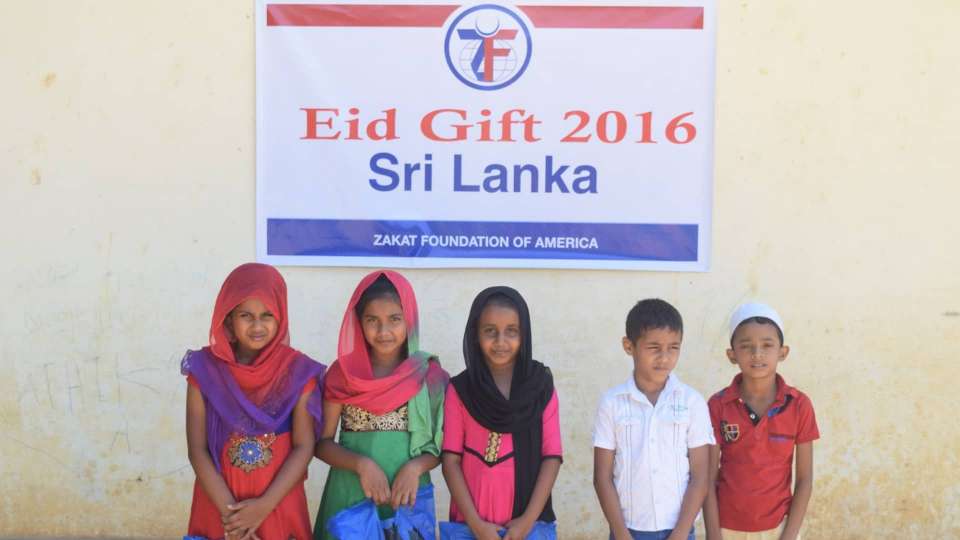 Children under an Aid Gift 2016 sign in Sri Lanka.