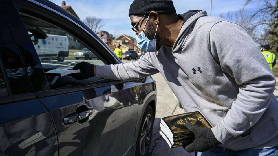 Imam Jihad Mu’Min hands out Qurans to people as they pickup food at a food distribution event in O’ Fallon Park in O’ Fallon on Saturday, Feb. 27, 2021. Every week Al-Mu’minun Islamic Center works with Zakat Foundation of America to donate food to approximately 1000 families in the St. Louis area. People are able to take as many boxes as they need and each truck brings about 1000 boxes a week. Cheyenne Boone ST. LOUIS POST-DISPATCH