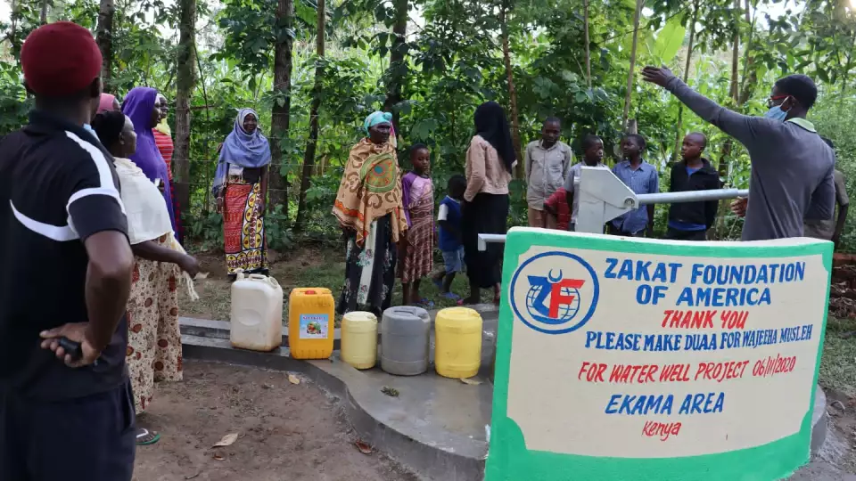 Representatives explain safe water sanitation practices to the community. – Zakat Foundation of America photo