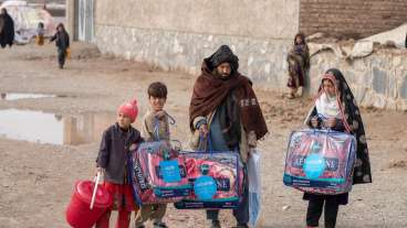 Juma Gul, 32, center, and his family carry blankets and other supplies distributed by UNICEF to protect the most vulnerable from the harsh Afghan winter. © UNICEF/UN0574507/BIDEL
