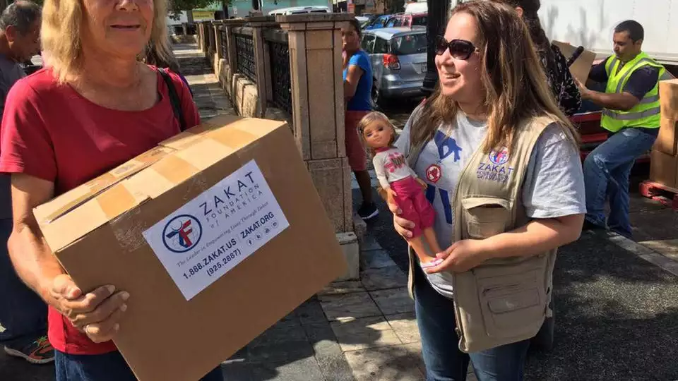 Leticia (right), Programs Coordinator at Zakat Foundation of America, speaks with a beneficiary (right), who gifted her the doll as a token of her thankfulness.