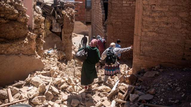 image of survivors walking through morroco earthquake rubble