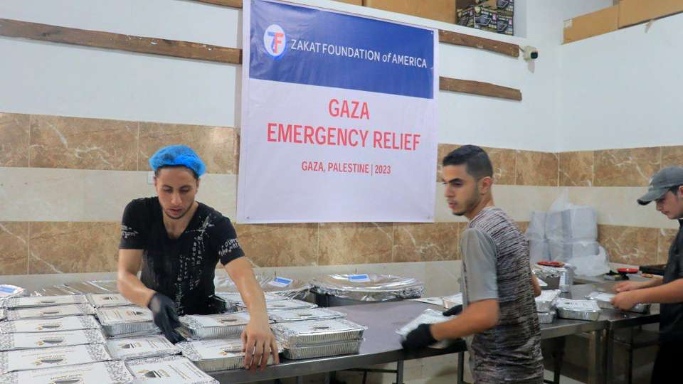 relief workers putting together meal kits for gaza emergency relief