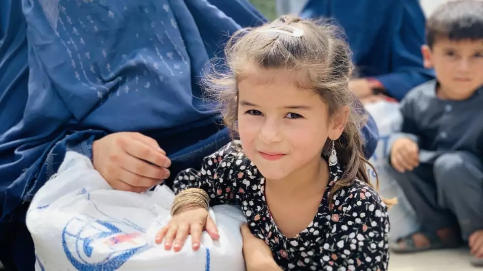 The excitement of a home cooked meal is contagious / طفلة تبدو سعيدة بعد تلقيها المساعدات