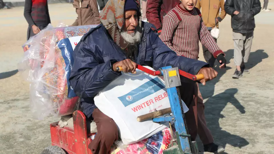 An elderly man from Pakistan receives winter essentials for his family