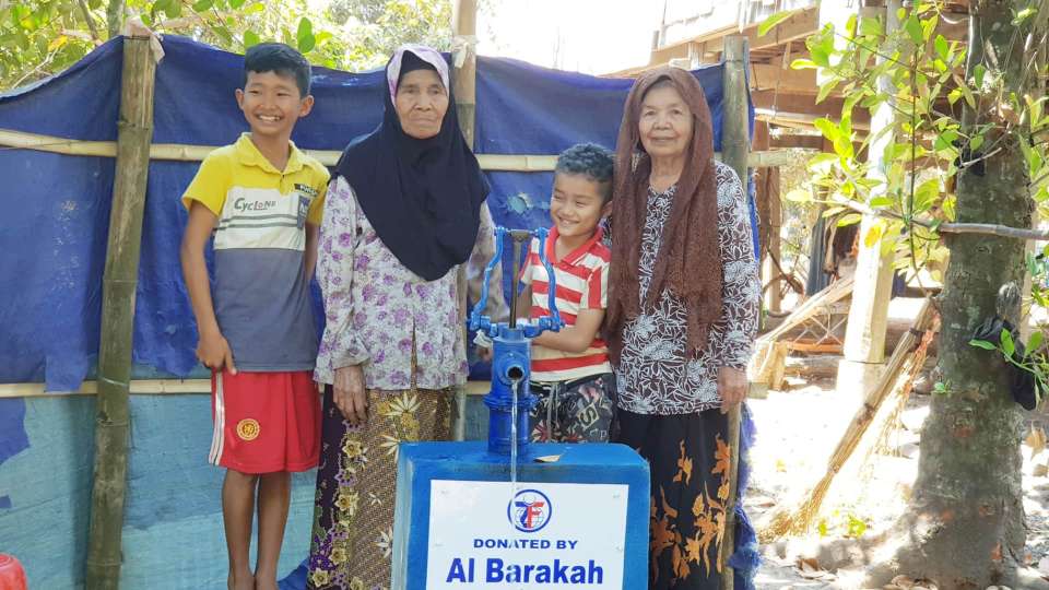 Family standing in front of a donated Water Well in Cambodia.
