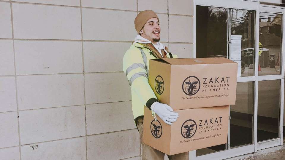 Zakat worker holding boxes