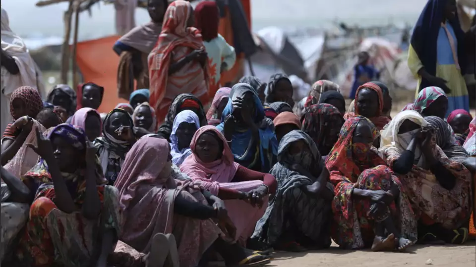 Displaced Sudanese women wait at our distribution site for emergency food relief to help feed their families