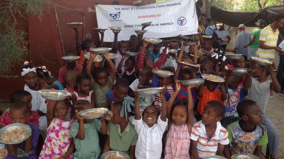 Children gathered and cheering their plates of food