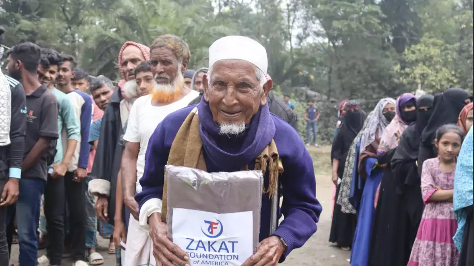 An elderly man in Bangladesh receives a warm shawl to help battle the winter chill