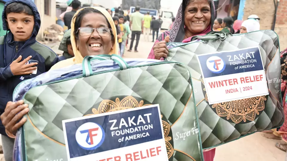 Mothers in India express their joy at receiving blankets to keep their families warm