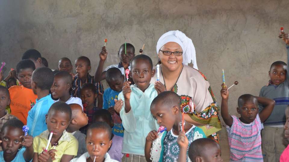 Health Advisor Donna Neil-Demir, RN, on a 2016 field visit to Rwanda, where she is seen with orphans and vulnerable children. Such children receive health care as part of their enrollment in Zakat Foundation of America’s orphan sponsorship program. | Zakat Foundation of America