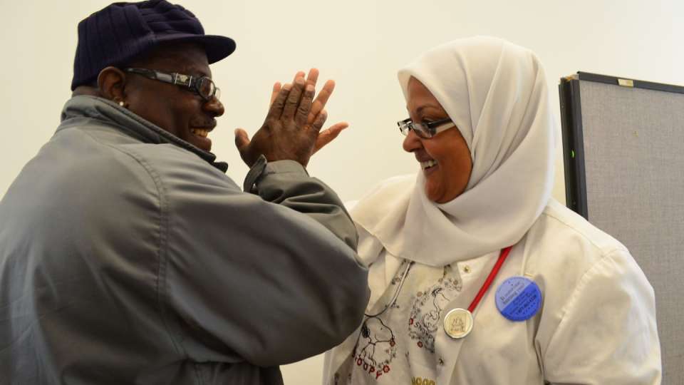 Donna Neil-Demir, RN, Zakat Foundation of America’s health advisor, high-fives a peer at an Inner-City Muslim Action Network (IMAN) event in Chicago called “Takin’ It to the Streets.” | Zakat Foundation of America photo