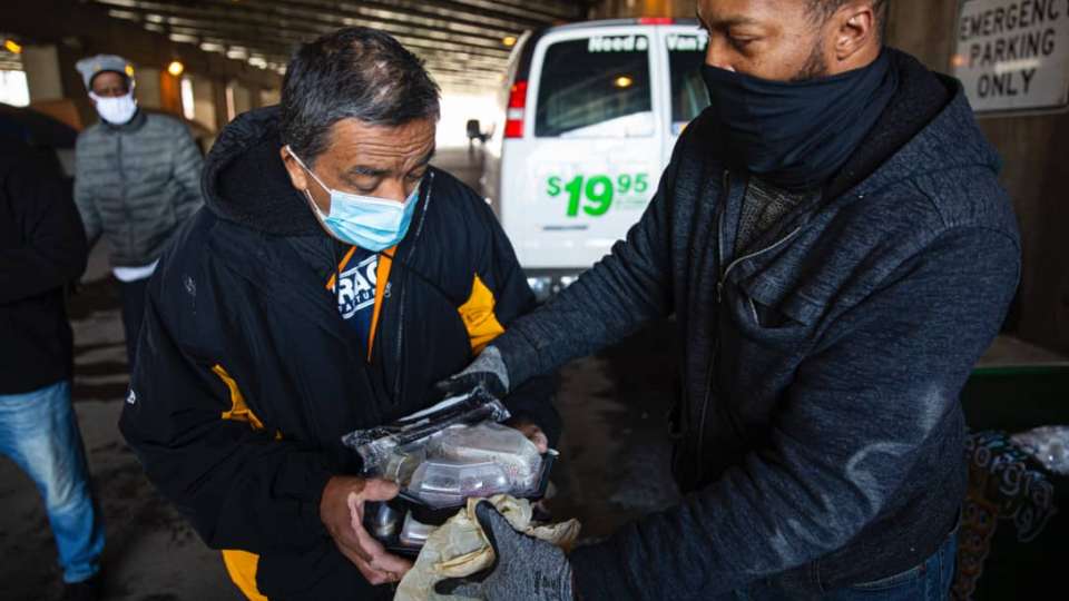 Julio Mendoza receives food from a volunteer on Thursday. Anthony Vazquez/Sun-Times
