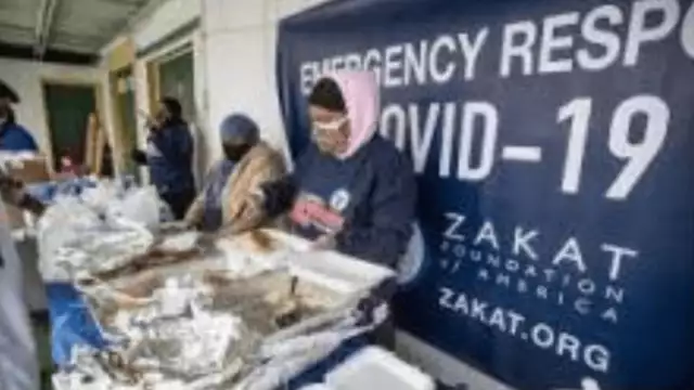 Volunteers organize boxes of food during a giveaway of hygiene packages and 250 hot meals in Greensboro