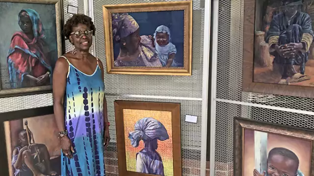 Jean Lewis with her pastel paintings behind her. She said she usually doesn't get to see them all at once like this because they're usually "in the corner somewhere" at her art studio. (Nick Ulanowski/H-F Chronicle)