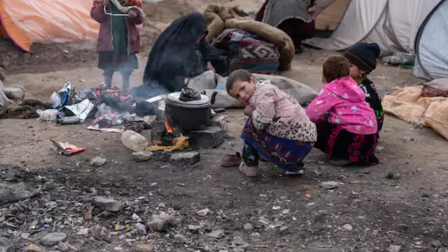 At the Shaydayee camp for displaced families in Herat Province, Suraya, 8, and her sisters huddle around an open fire to try to stay warm. UNICEF is distributing blankets, winter clothing and other supplies to children and families in Afghanistan. © UNICEF/UN0574509/BIDEL