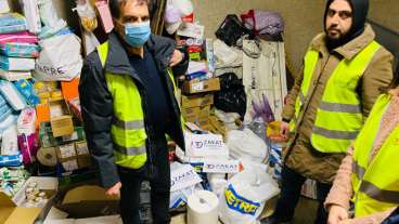 Supplies for Ukrainian refugees in Moldova surround Mehmet Demir, left, of Zakat Foundation. (Courtesy of Zakat Foundation)