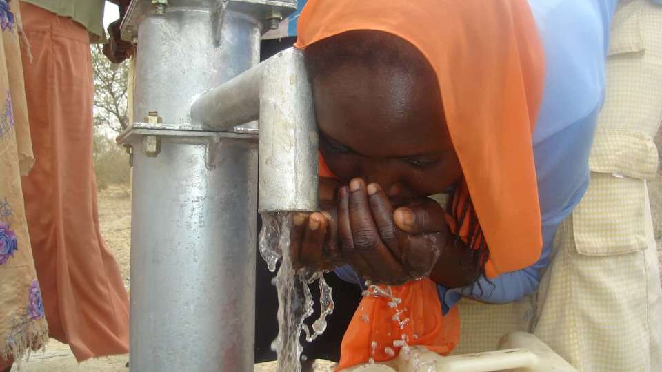 Girl drinks from well darfur sudan