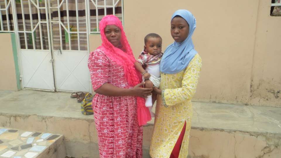 Amina (right) holds her cousin and poses with her uncle's wife.