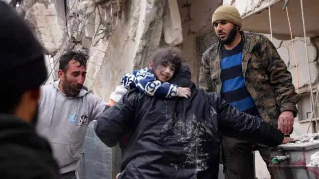 Residents retrieve a child from the rubble of a collapsed building in the town of Jandaris, in the countryside of Syria’s northwestern city of Afrin on Monday. Rami Al Sayed / AFP – Getty Images
