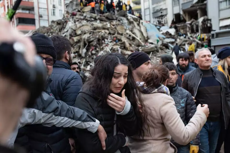 A woman reacts as rescuers search for survivors through the rubble of collapsed buildings in Adana, Turkey, on Feb. 6, 2023, after a 7.8 magnitude earthquake struck the country. (Can Erok/AFP Getty)
