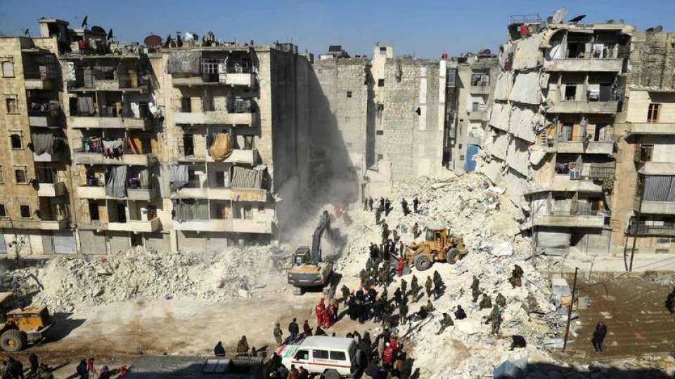 Syrian soldiers look on as rescuers use heavy machinery sift through the rubble of a collapsed building in the northern city of Aleppo, searching for victims and survivors days after a deadly earthquake hit Turkey and Syria, on Feb. 9, 2023. The 7.8-magnitude quake early on February 6 has killed more than 17,000 people in Turkey and war-ravaged Syria, according to officials and medics in the two countries, flattening entire neighborhoods. (AFP via Getty Images)