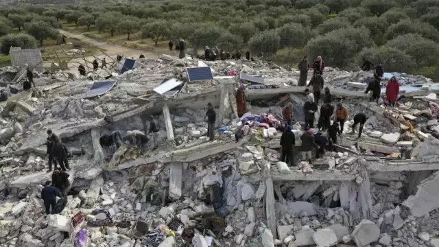 Civil defense workers and residents search through the rubble of collapsed buildings in the town of Harem near the Turkish border, Idlib province, Syria, Monday, Feb. 6, 2023. A powerful earthquake has caused significant damage in southeast Turkey and Syria and many casualties are feared. Damage was reported across several Turkish provinces, and rescue teams were being sent from around the country. (AP Photo/Ghaith Alsayed)
