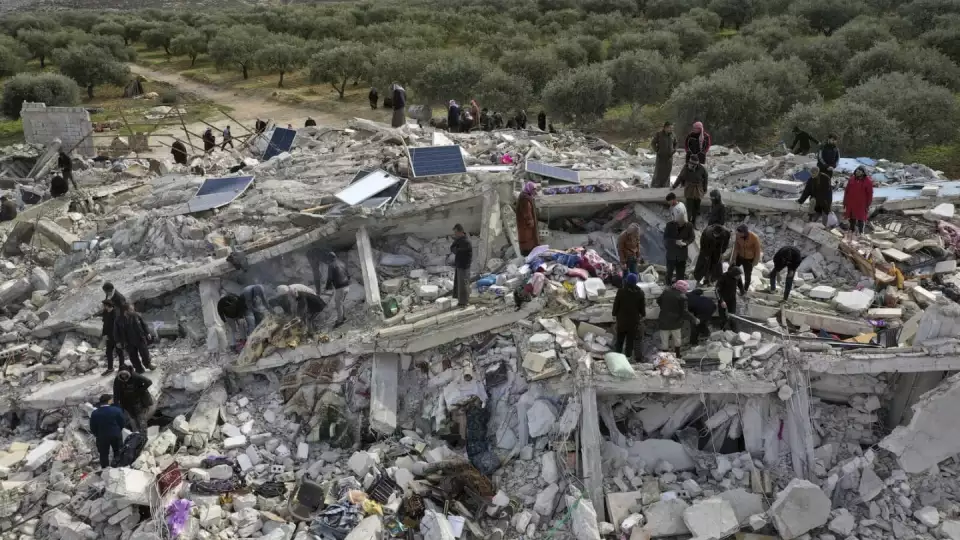 Civil defense workers and residents search through the rubble of collapsed buildings in the town of Harem near the Turkish border, Idlib province, Syria, Monday, Feb. 6, 2023. A powerful earthquake has caused significant damage in southeast Turkey and Syria and many casualties are feared. Damage was reported across several Turkish provinces, and rescue teams were being sent from around the country. (AP Photo/Ghaith Alsayed)
