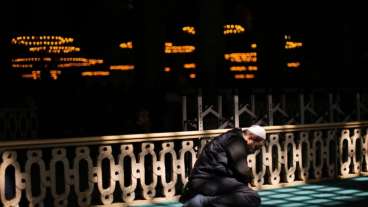 Muslim man sitting on ground in mosque praying