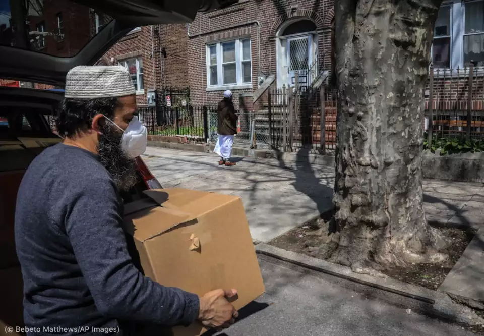 Volunteers with An-Noor Cultural Center in Elmhurst, New York, deliver food on April 22 to a family quarantined during the COVID-19 crisis. (© Bebeto Matthews/AP Images)