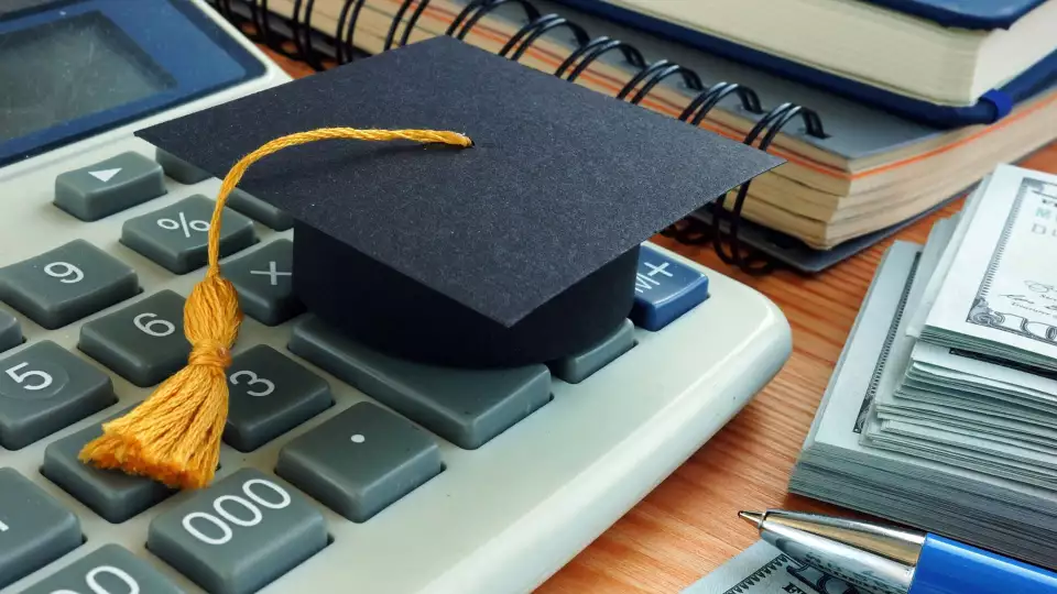 image of calculator money pen little graduation hat on table