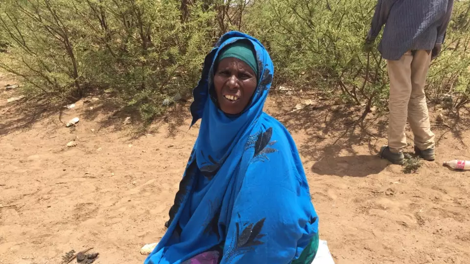 A woman receives life sustaining food provisions / امرأة تتلقى المواد الغذائية