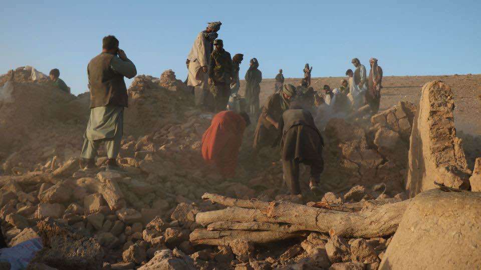 Afghanistan civilians standing on building rubble