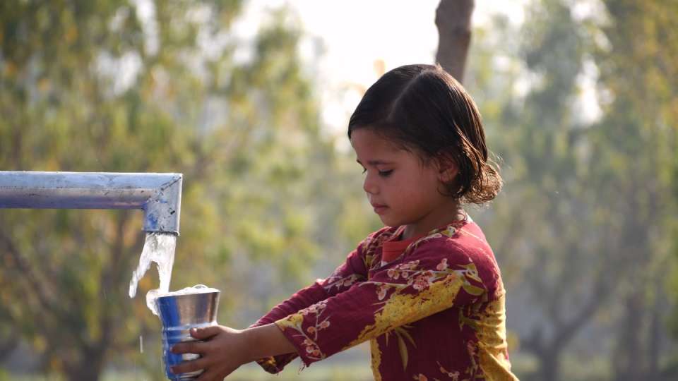 Transforming lives with clean drinking water / طفلة تحصل على مياه الشرب النظيفة