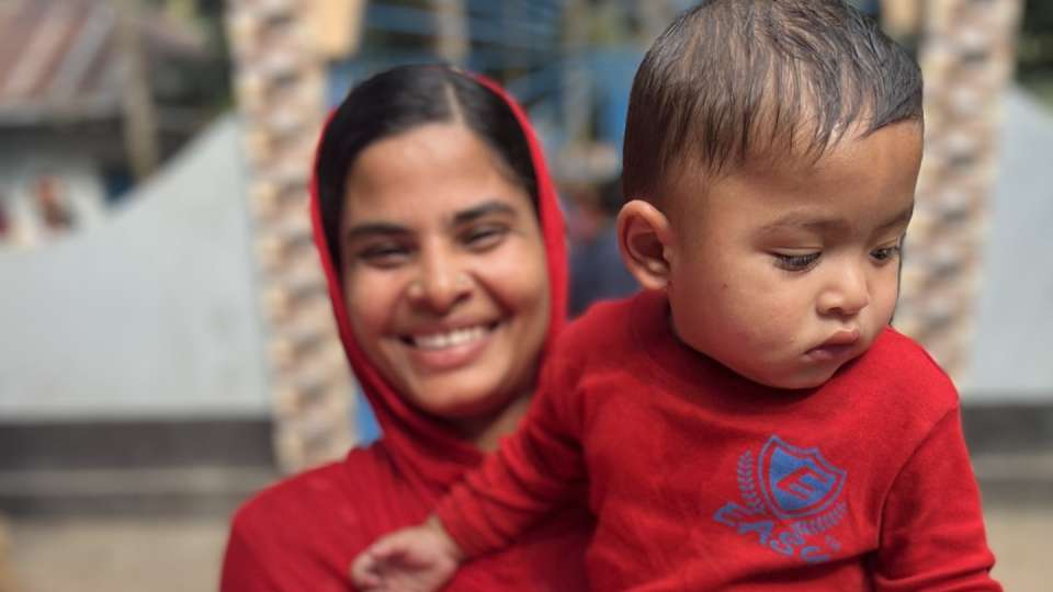 A mother in Bangladesh happily accepts winter relief / أمراة من بنغلاديش سعيدة لتلقيها الإغاثة الشتوية