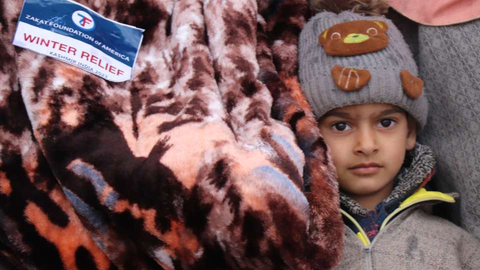 A warm blanket to protect a child in Kashmir / بطانية دافئة لحماية طفل في كشمير