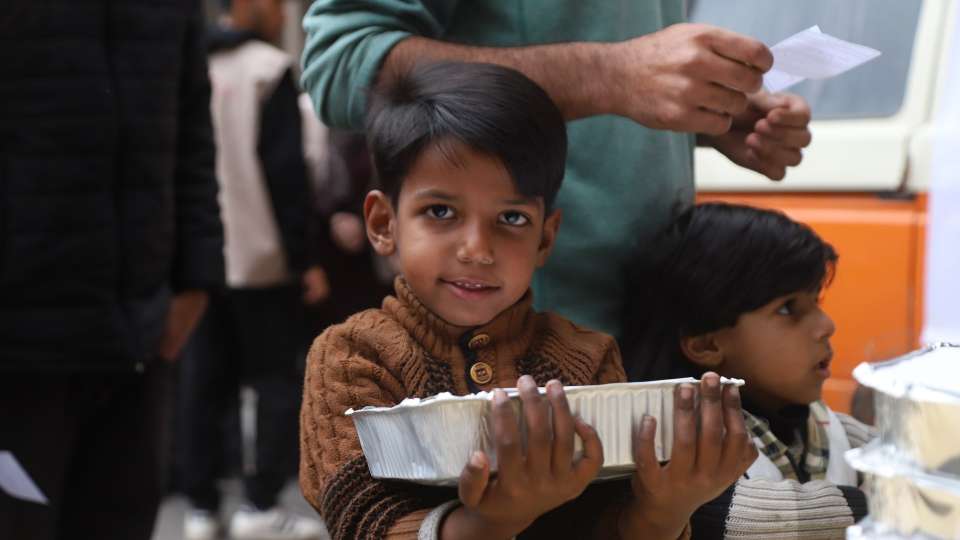 A child clutches his hot meal in Gaza
