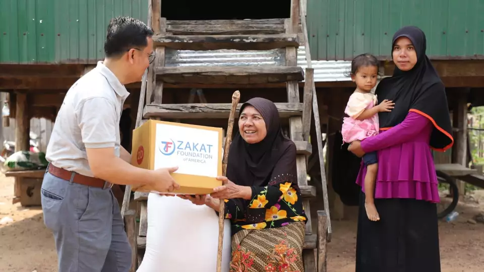 A food package is delivered to a family in Cambodia / عائلة في كمبوديا تستلم طرد غذائي