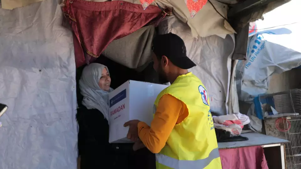 A grateful mother receiving your Ramadan food package / امرأة تتلقى طرد غذائي رمضاني