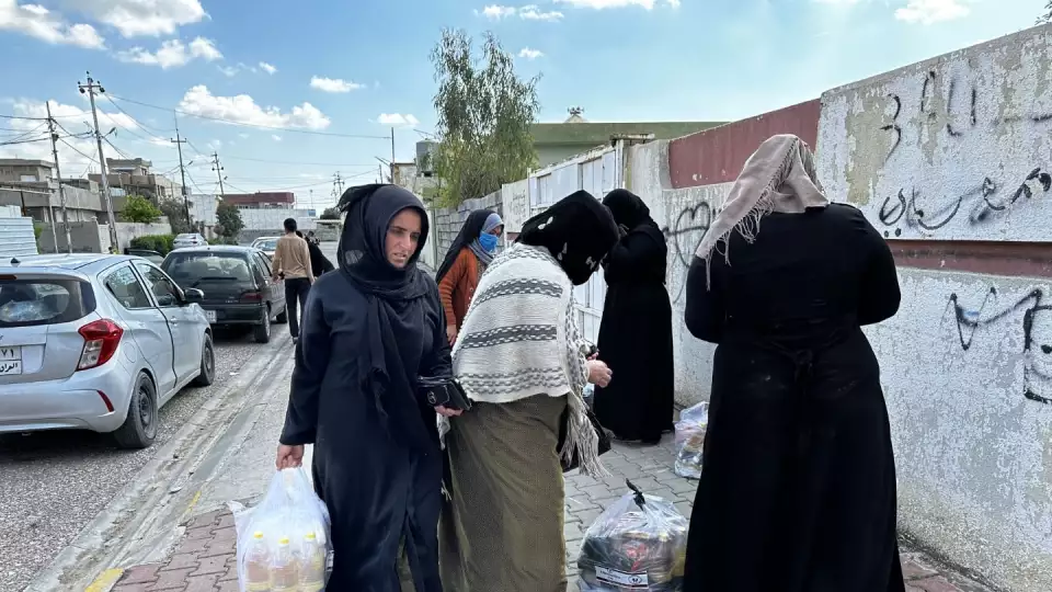 Women take home food packages in Iraq