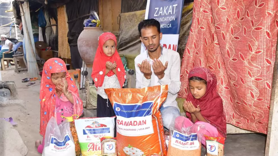 A Rohingya family in India receives a food package