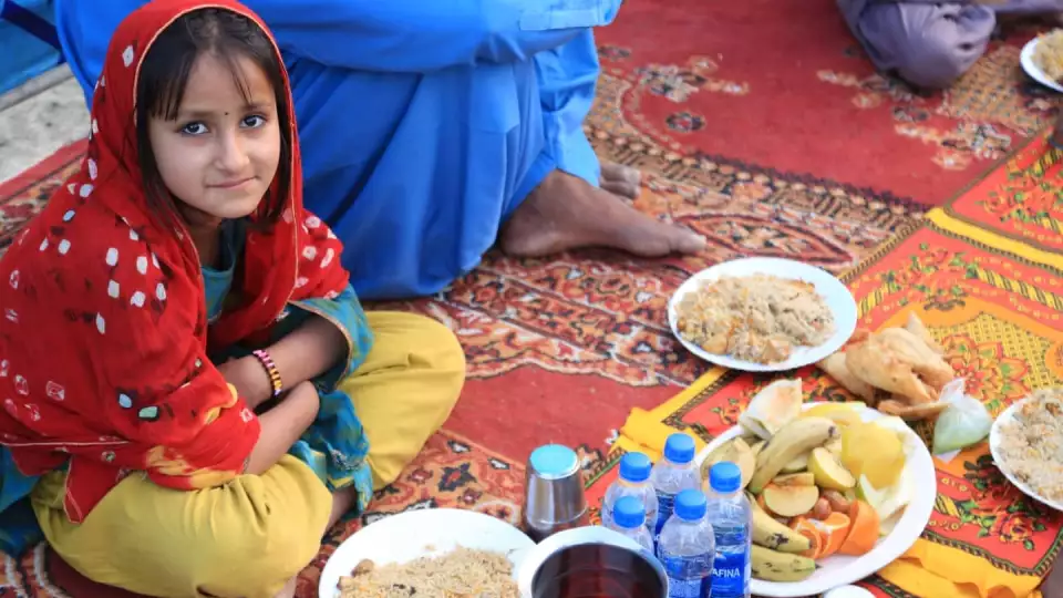 A little girls waits to enjoy her iftar meal