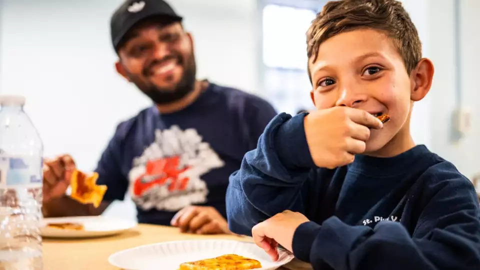 Osmar Ortiz from Venezuela digs in as migrants were welcomed with a dinner at the recently opened migrant shelter at St. Bartholomew Catholic Church in Portage Park on June 11, 2024. Credit: Colin Boyle/Block Club Chicago