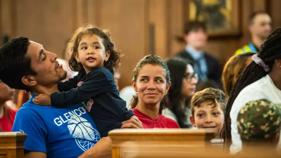 Mia Aponte plays with her dad, Jose Moreno, as migrants were welcomed with a dinner at the recently opened migrant shelter at St. Bartholomew Catholic Church in Portage Park on June 11, 2024. Credit: Colin Boyle/Block Club Chicago