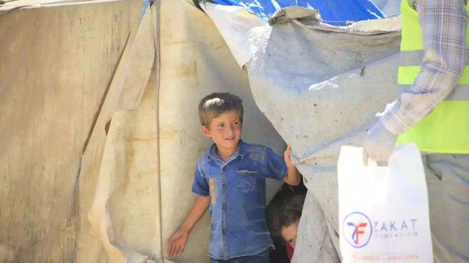 A Zakat Foundation of America representative visits the emergency tent village to distribute food and items