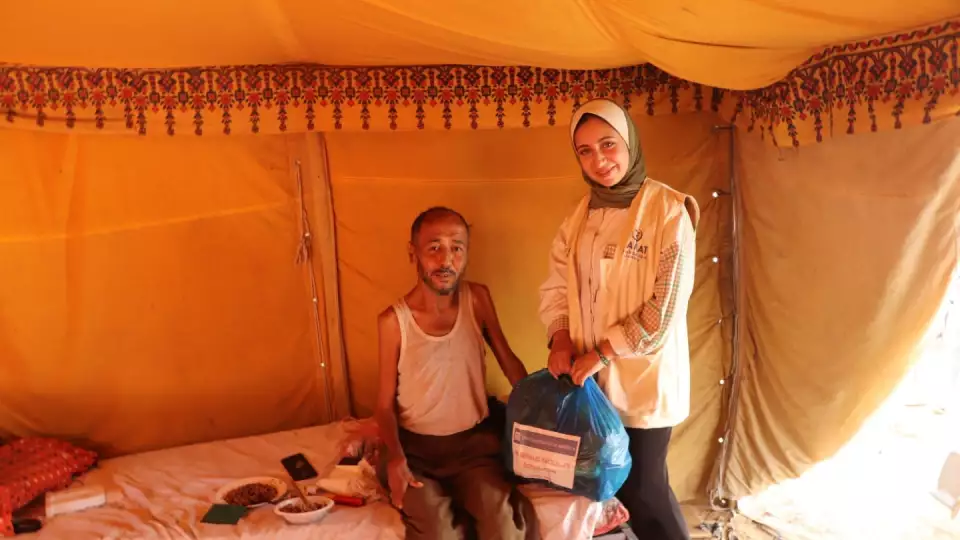 Many displaced people are living in tents in Gaza. Here a man receives an emergency food package from Zakat Foundation of America