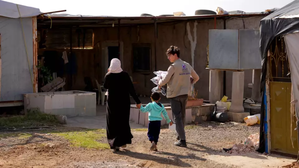 A Zakat Foundation of America field rep helps a mother take her winter relief items home.