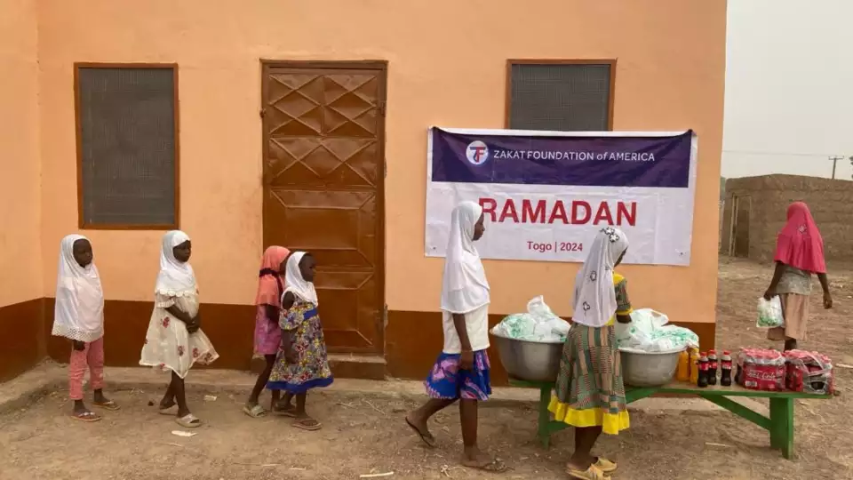 Children in Togo line up for food packages and can now focus on school.